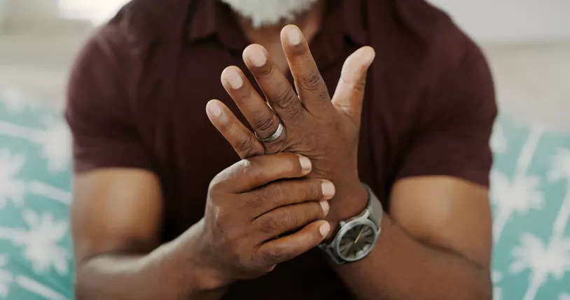 Homem segurando a mão com artrite