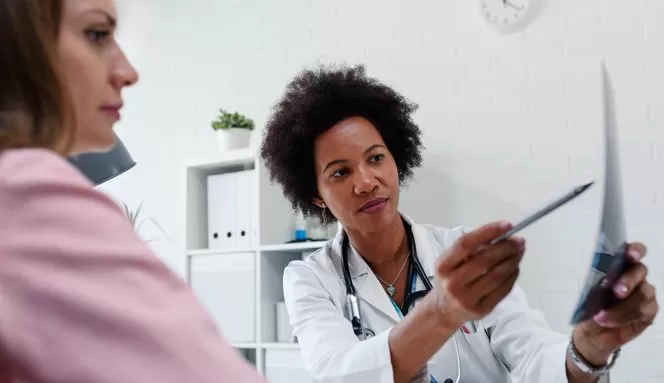 médica mostrando tratamentos de câncer para a paciente 